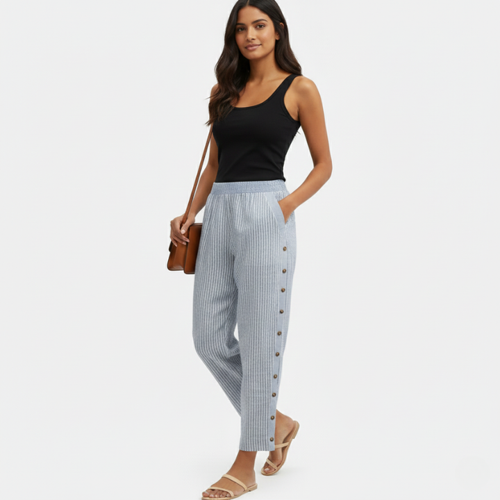 Woman wearing a black tank top and striped pants on a white background