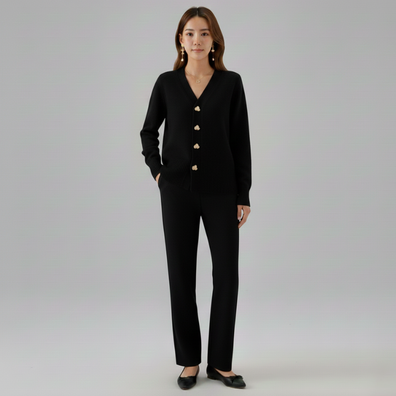 Woman wearing a black outfit with gold buttons on a gray background