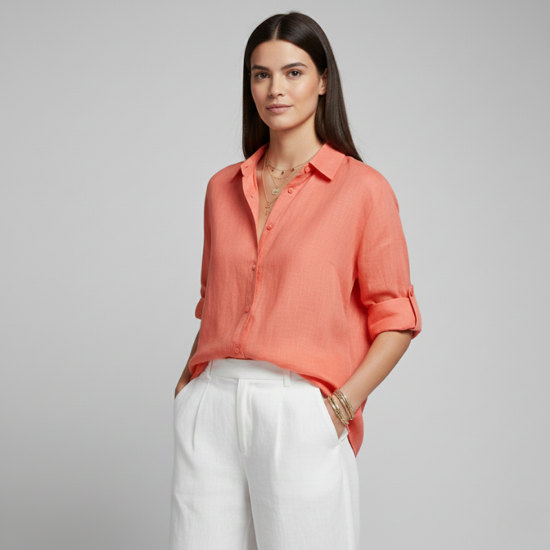 Woman wearing a coral shirt and white pants on a gray background