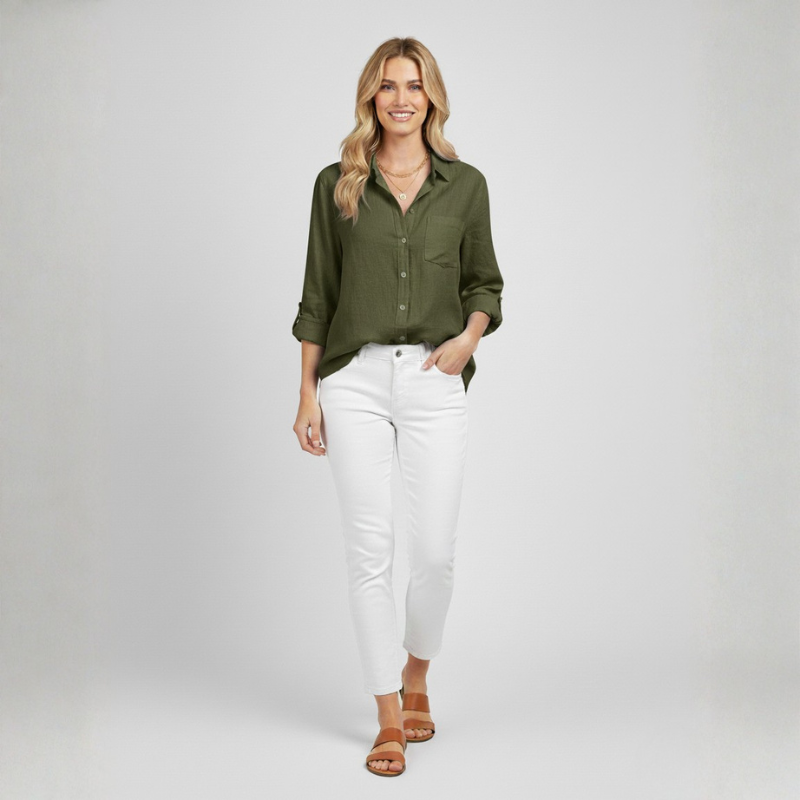 Woman wearing a green shirt and white pants on a plain background