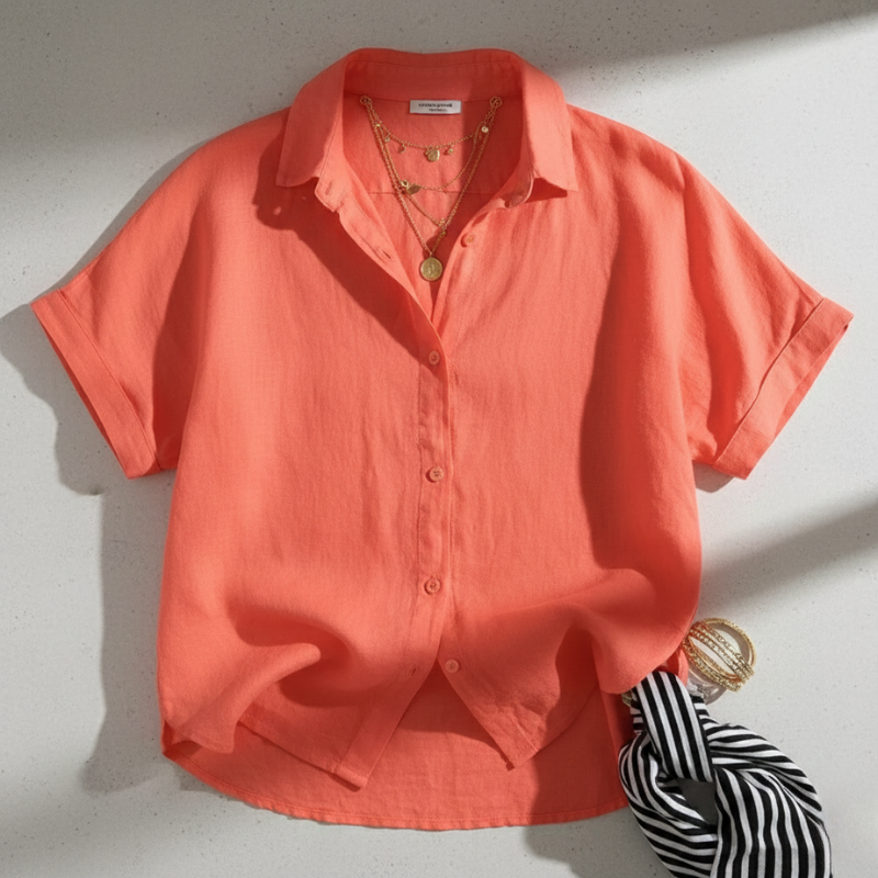 Coral shirt with accessories on a light gray background