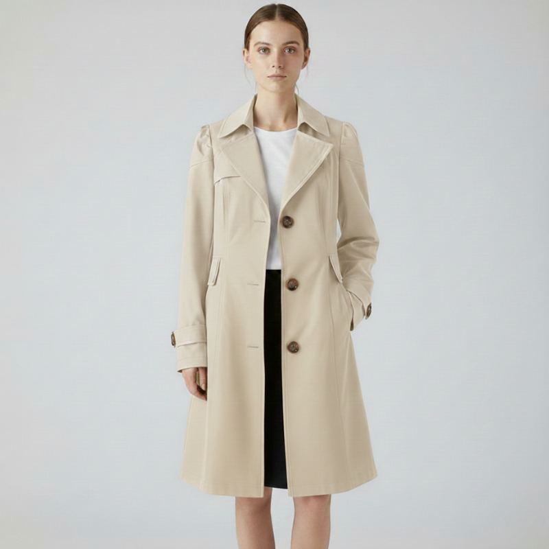 Female model posing in a light beige tailored coat with a minimalist, timeless design.