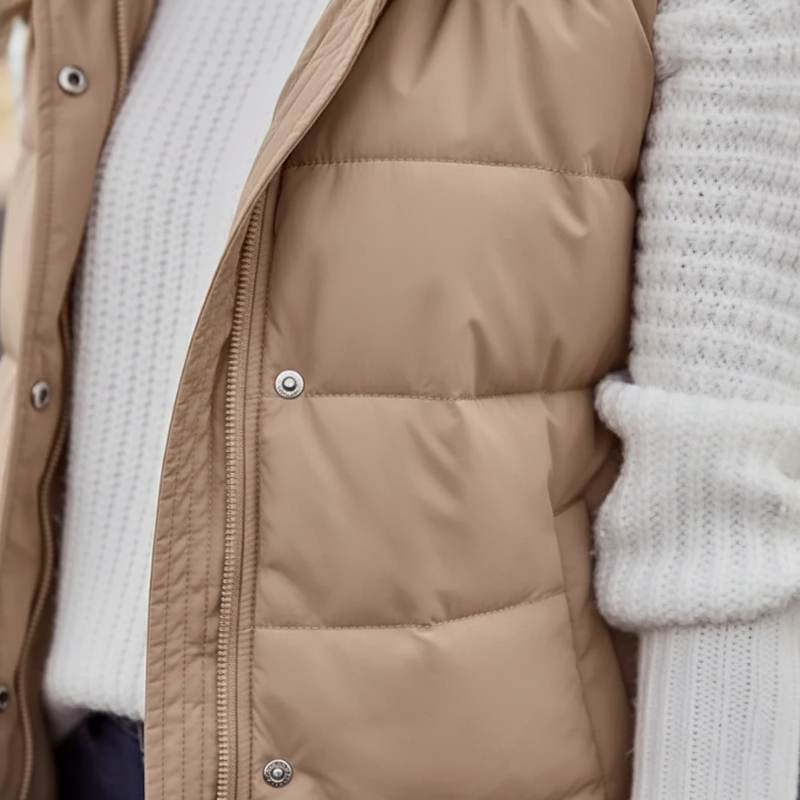 model walking in beige hooded long puffer vest styled with casual winter outfit