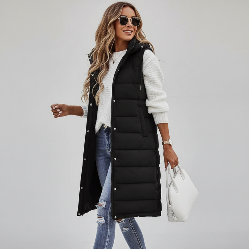 model wearing black sleeveless puffer vest layered over white top and jeans