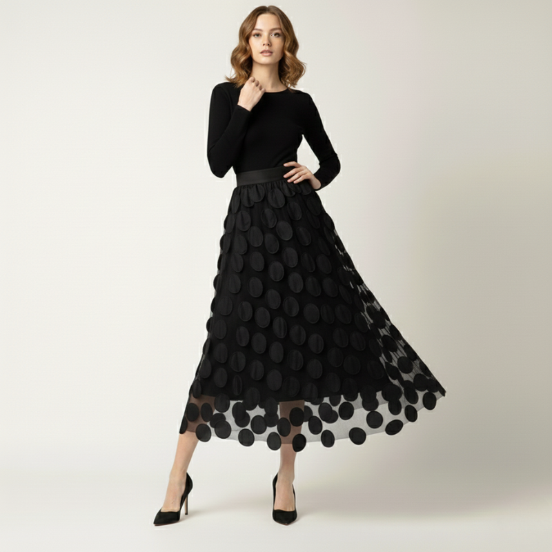 Woman wearing a black dress with a polka dot pattern on a white background