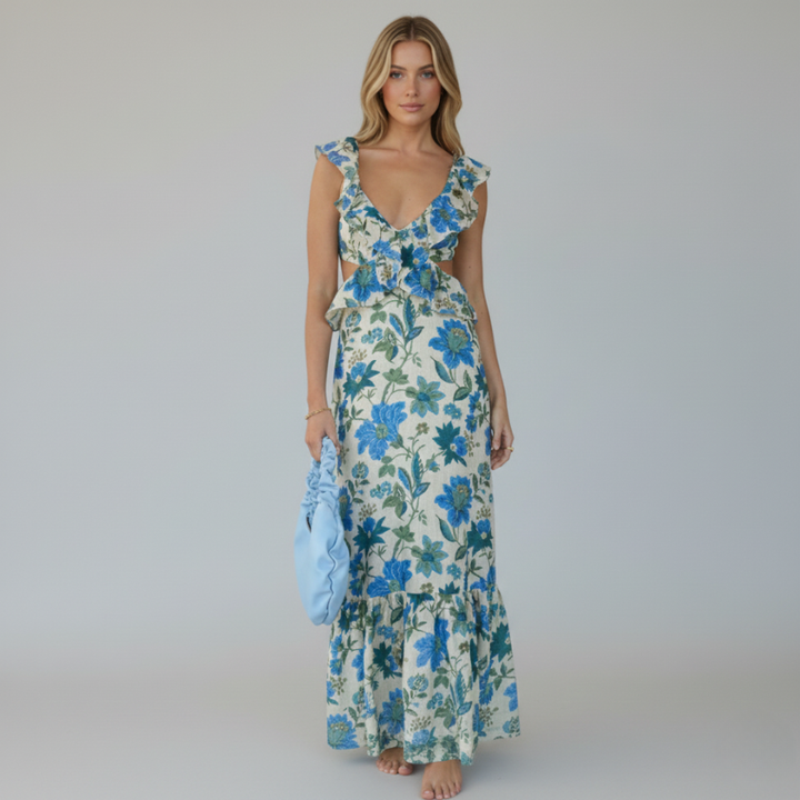 Model wearing a blue floral ruffle maxi dress in a full-length studio photograph.