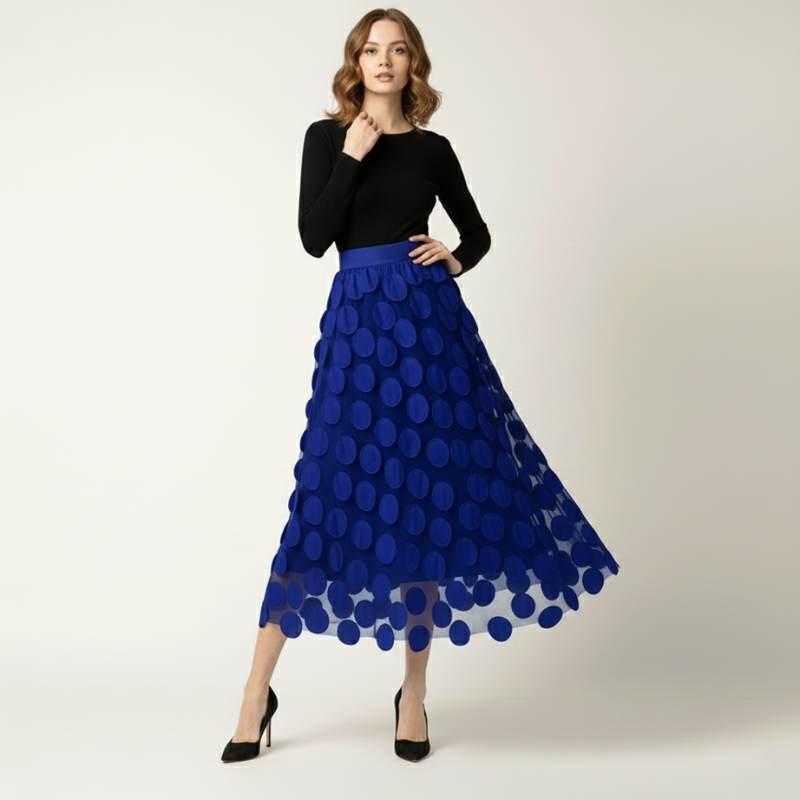 Woman wearing a black top and blue polka dot skirt on a white background