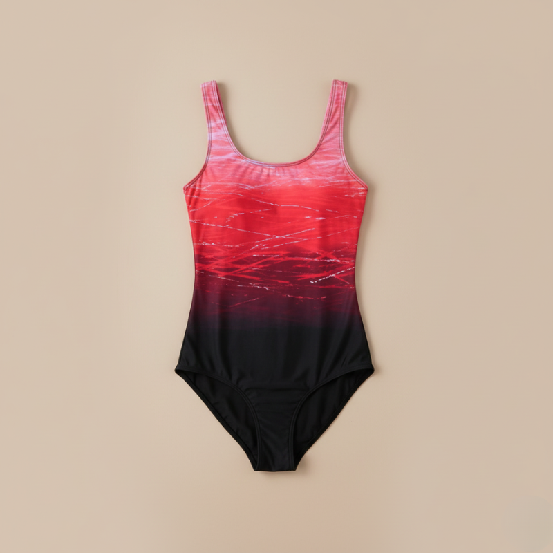 Pink-to-black gradient one-piece swimsuit laid flat on a neutral background showing full design and cut.