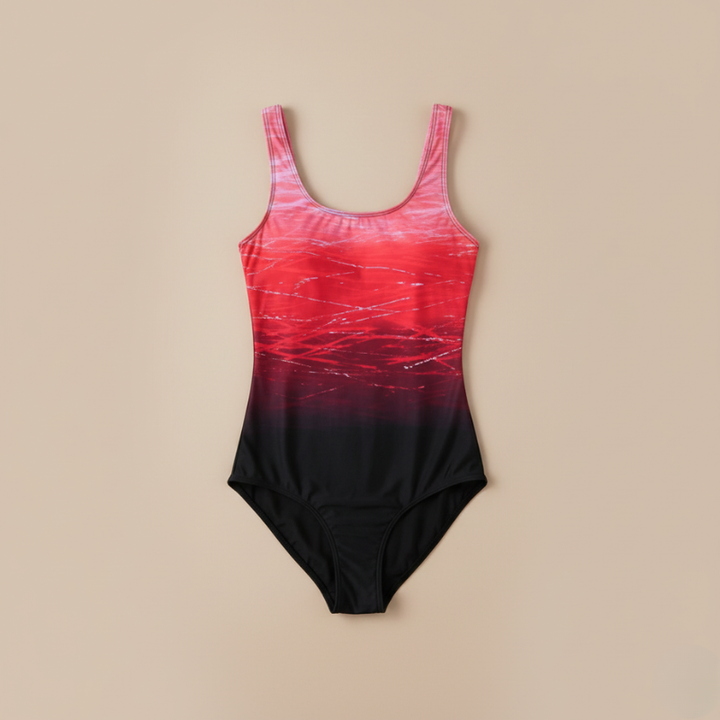 Pink-to-black gradient one-piece swimsuit laid flat on a neutral background showing full design and cut.