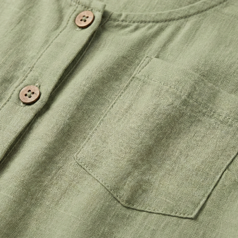 closeup of green sleeveless top showing fabric texture and button stitching