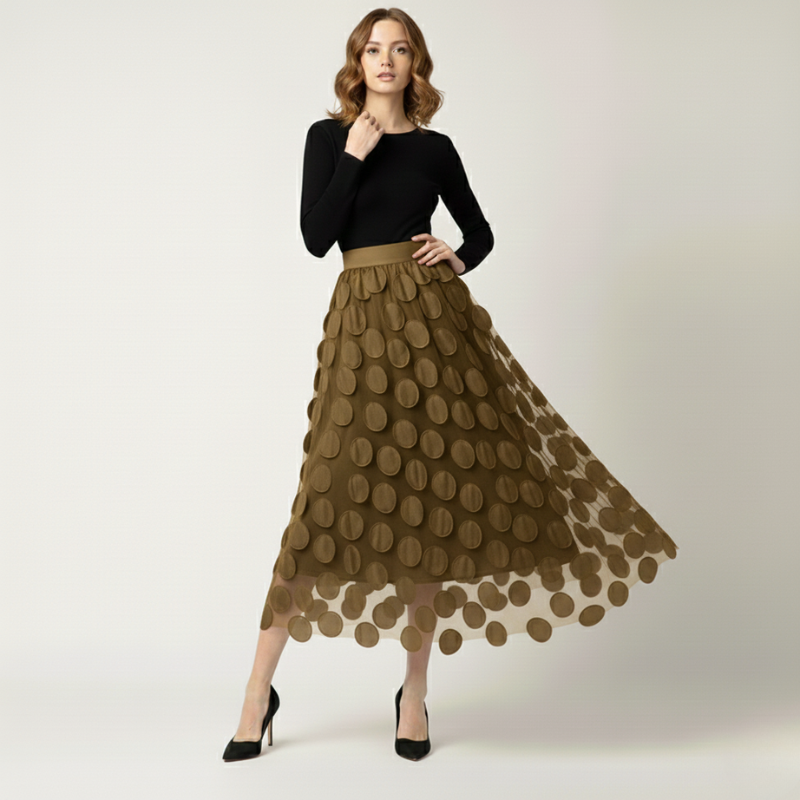 Woman wearing a black top and brown polka dot skirt on a white background