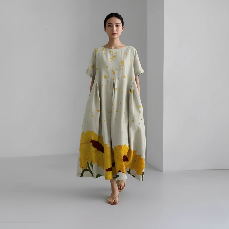 Woman wearing a floral dress with sunflower design on a plain background