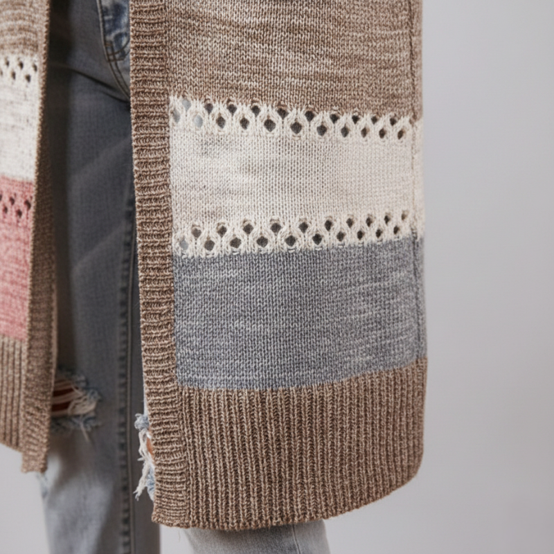 Close-up of the cardigan’s patchwork knit showing mixed stitches, textured yarns, and soft neutral colors.