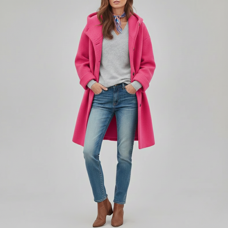 Person wearing a bright pink coat, light blue jeans, and brown shoes on a plain background