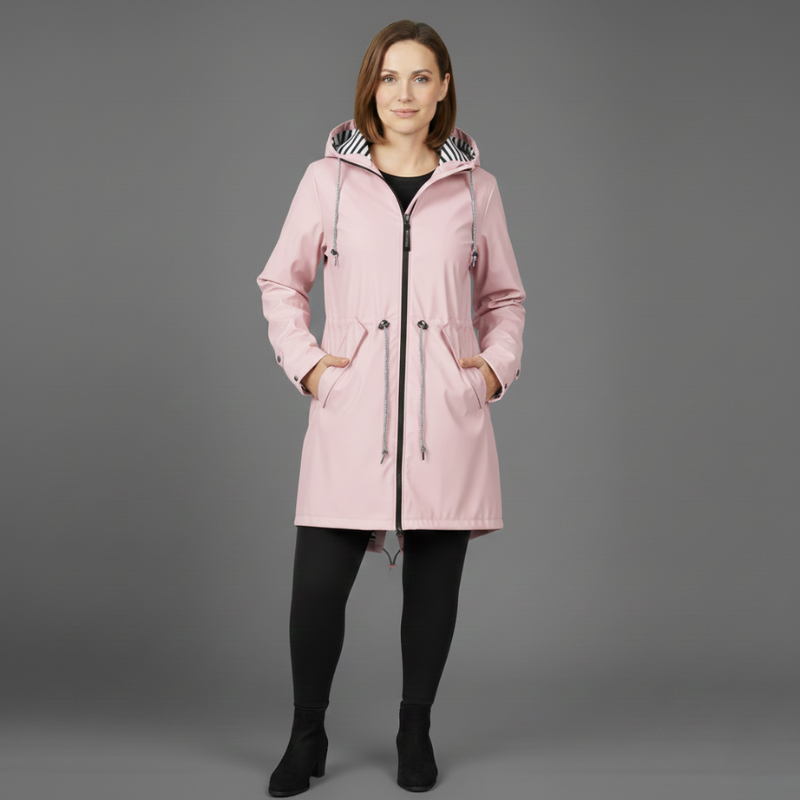 Female model posing in a light pink hooded winter coat on a gray background.