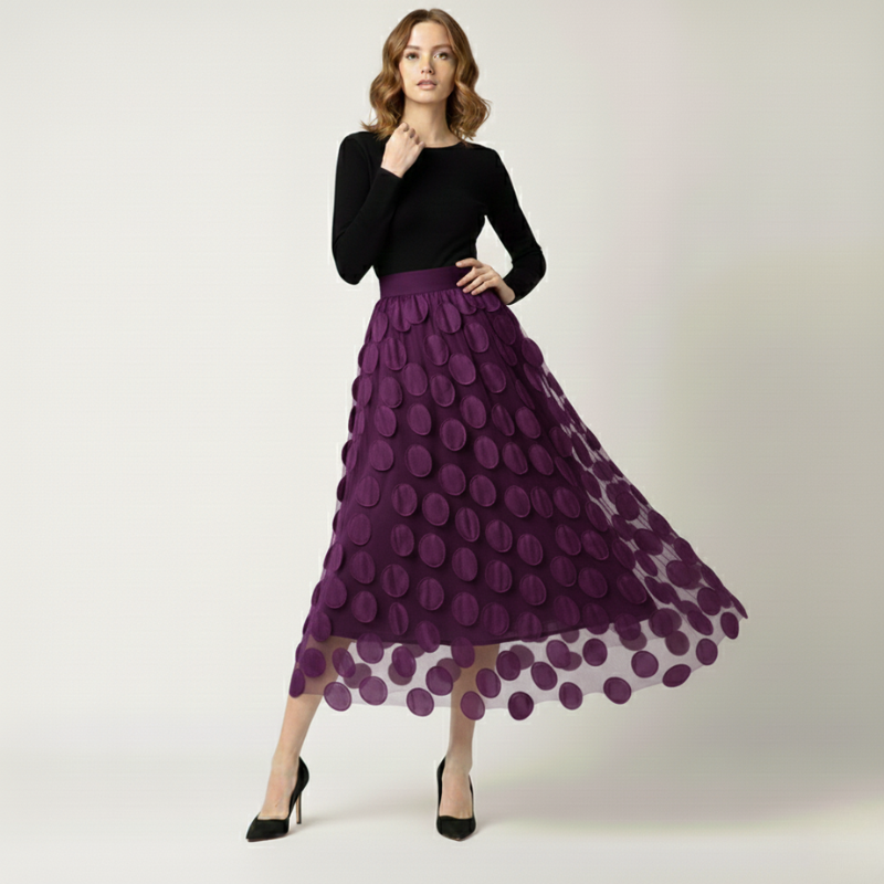 Woman wearing a black top and purple skirt with a white background