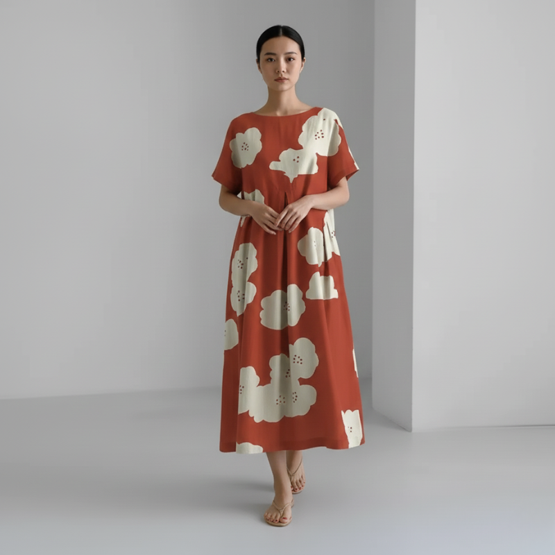 Woman wearing a red dress with white floral patterns against a plain background