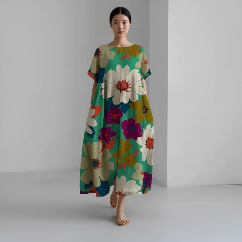 Woman wearing a colorful floral dress against a plain background
