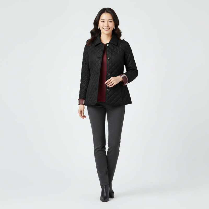 Female model wearing a black quilted jacket styled with dark pants in studio lighting.