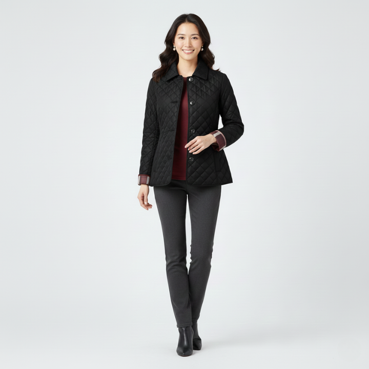 Female model wearing a black quilted jacket styled with dark pants in studio lighting.