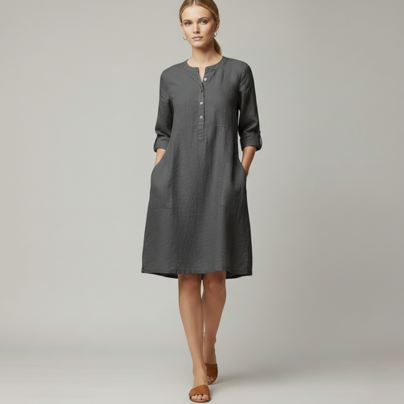 Woman wearing a gray knee-length casual dress with 3/4 sleeves and button neckline in a clean studio setting.