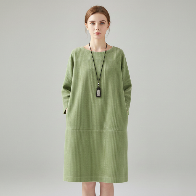 Female model in a green long-sleeve casual dress with a relaxed silhouette and pocket details.