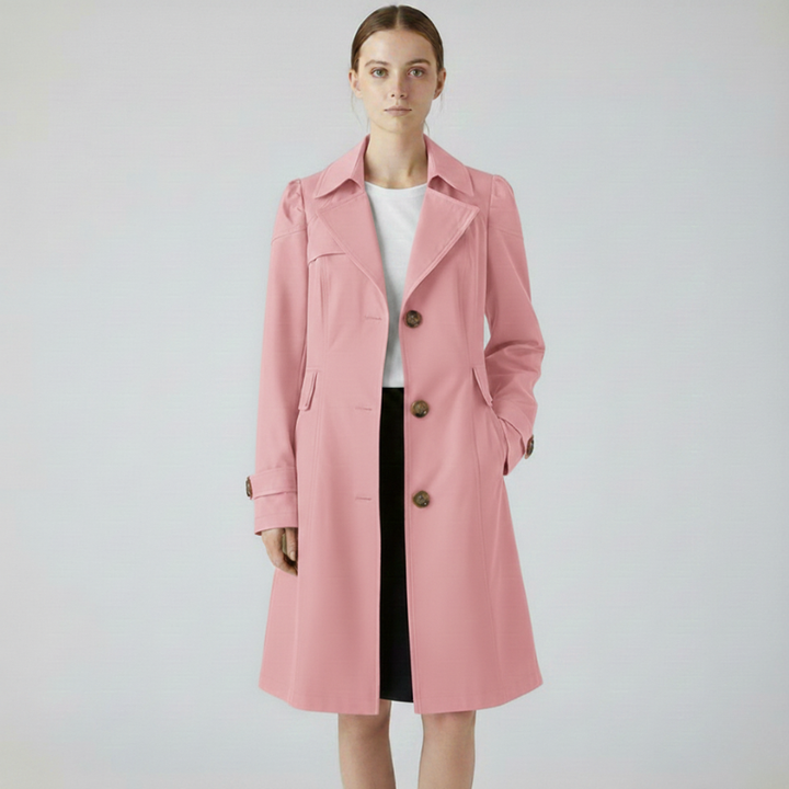 Woman wearing a pink long tailored coat styled for a polished, elegant look.