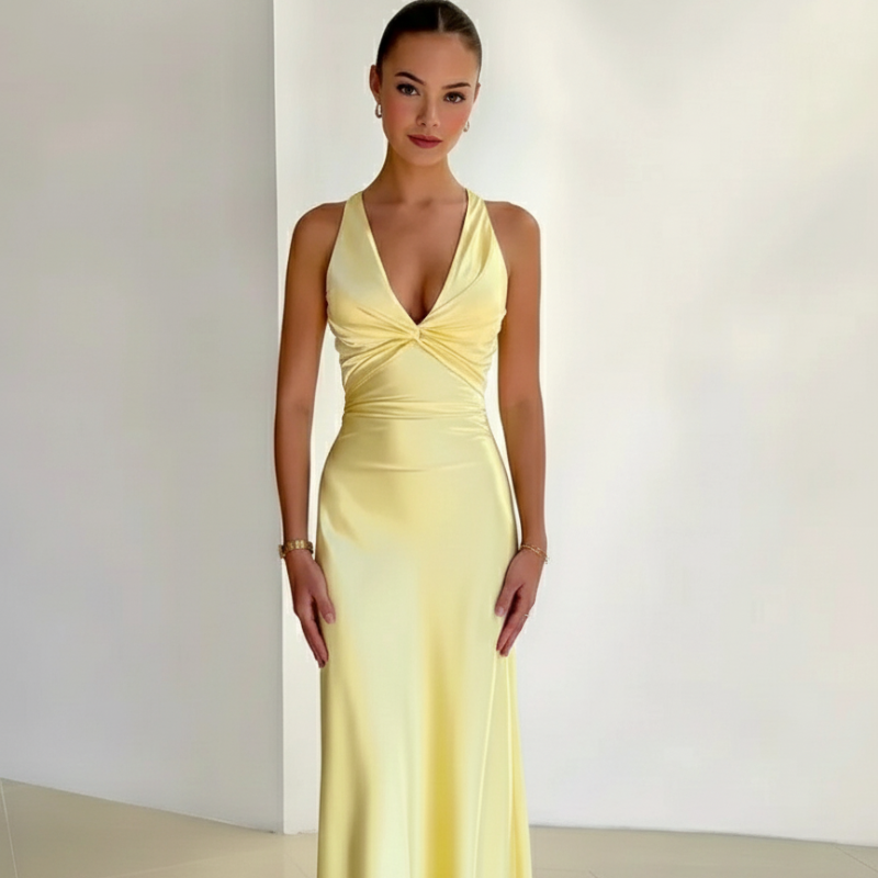 Side-angle shot of a woman wearing a yellow satin-style dress with a flattering V-neck and smooth draped finish.
